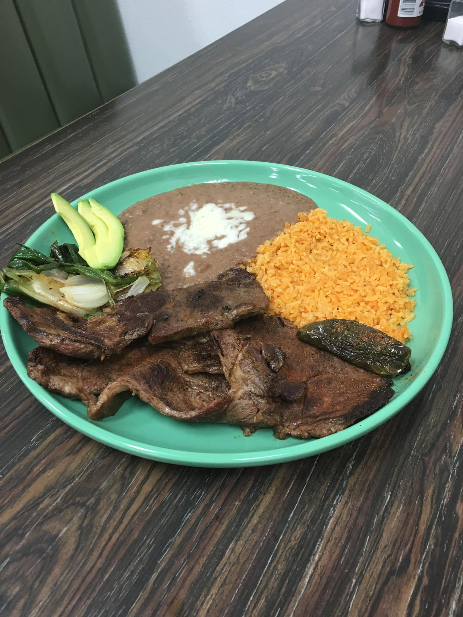 Bistek a la mexicana plate with rice, beans and avocado